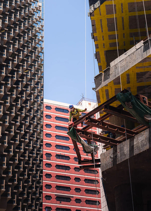 Street Photography shot of a construction worker perched on the building it is working on in Wanchai, Hong Kong.  Fine Art Limited Edition of 28. Photo © Copyright by Sylvère Clerempuy.