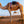 Camel standing on sand dunes with another camel and a person in the background.
